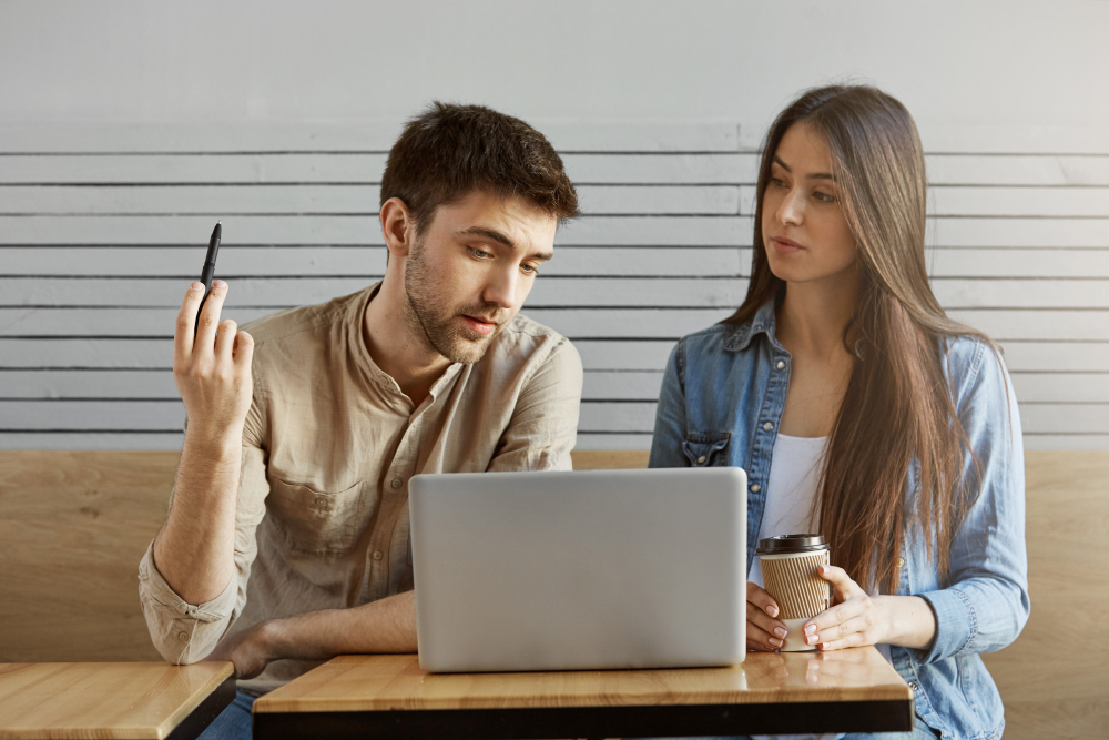 Man and woman discussing a task on laptop